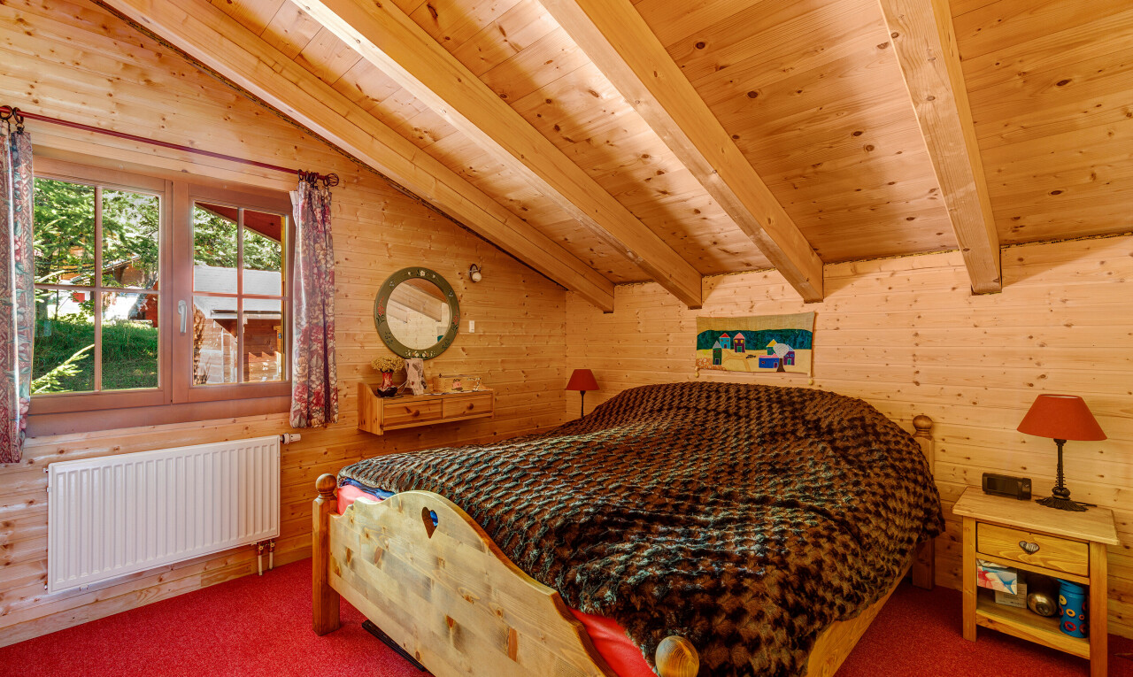 chambre avec beamed ceiling, plafond à poutres, inside property, radiateur, et wood wall