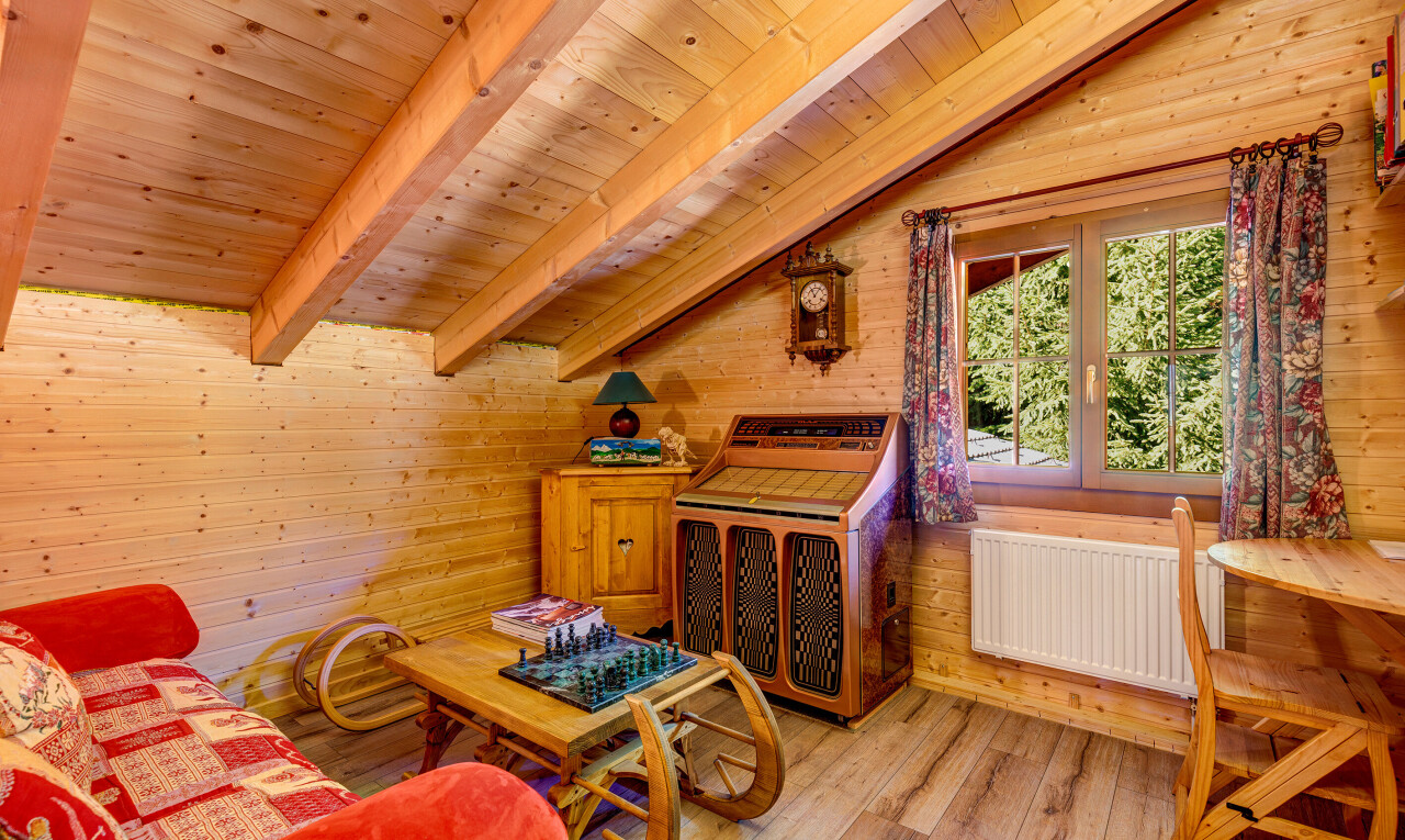 salon avec beamed ceiling, plafond à poutres, wood finish floor, sol en finition bois, et natural light