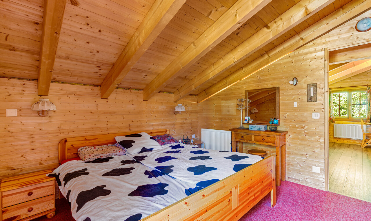 chambre avec mur en bois, wood wall, inside property, plafond à poutres, et beamed ceiling