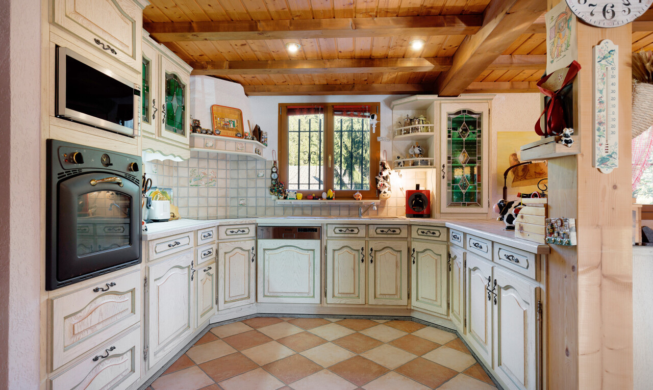 cuisine avec armoires en arc, four, backsplash, dosseret, et armoires élevées