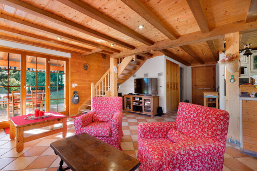 salon avec beamed ceiling, plafond à poutres, wood wall, mur en bois, et escaliers