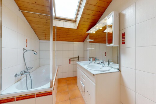 salle de bains avec mur en carrelage, tile wall, double vasque, miroir, et inside property