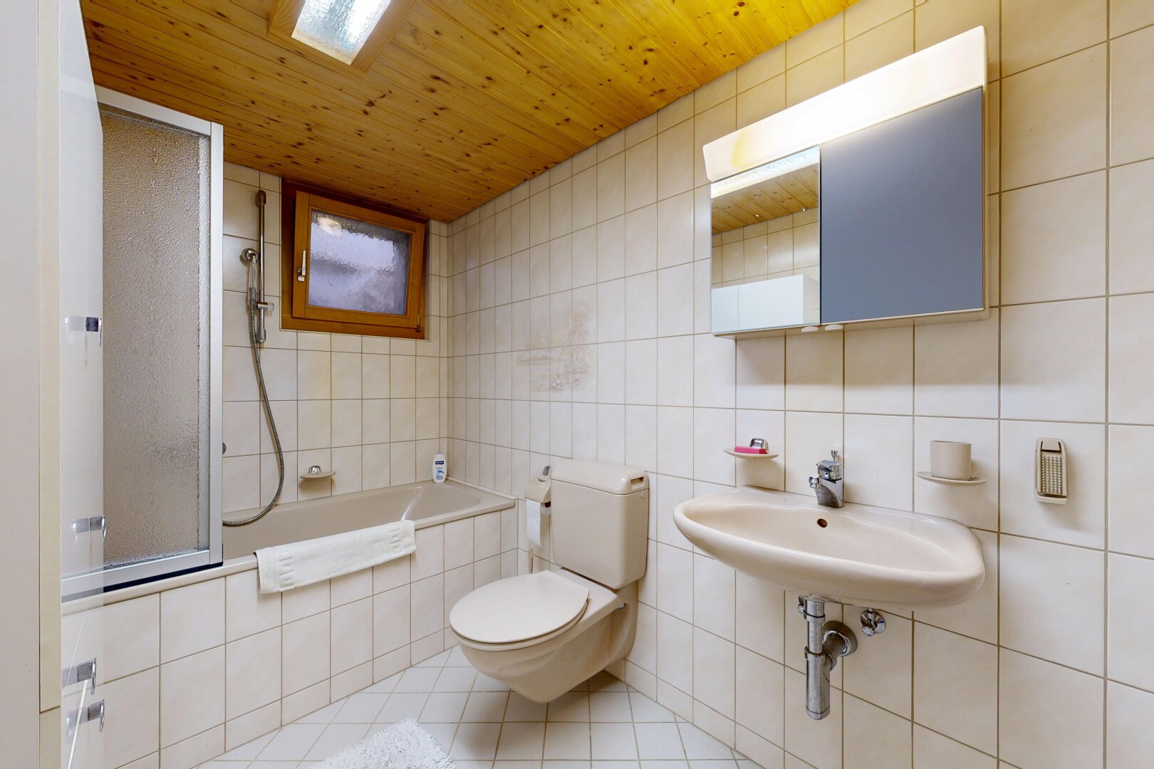 salle de bains avec miroir, toilette, salle de bain complète, tile wall, et mur en carrelage