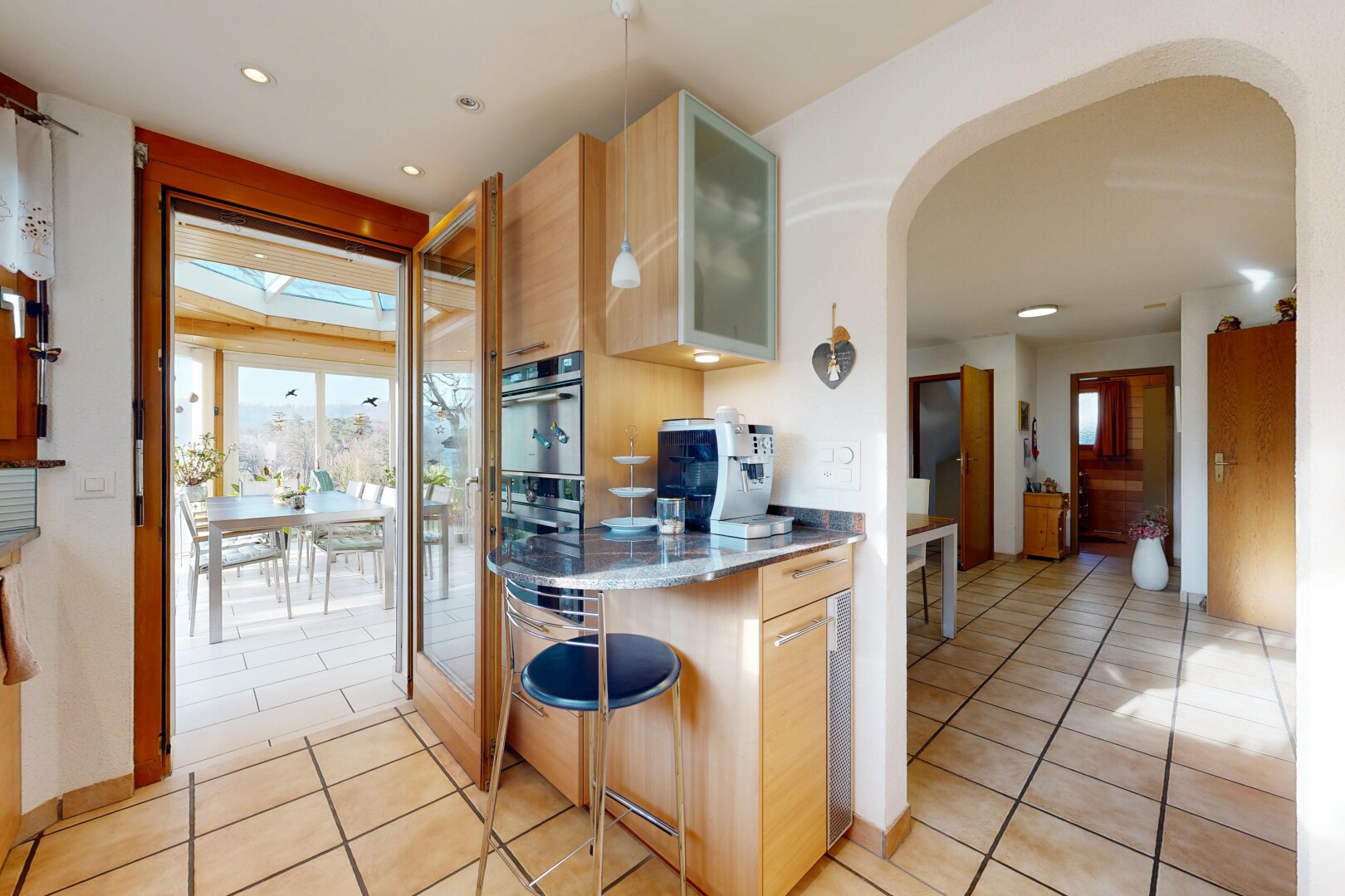 cuisine avec curved countertops, armoires avec insert en verre, glass insert cabinets, drywall, et cloison sèche