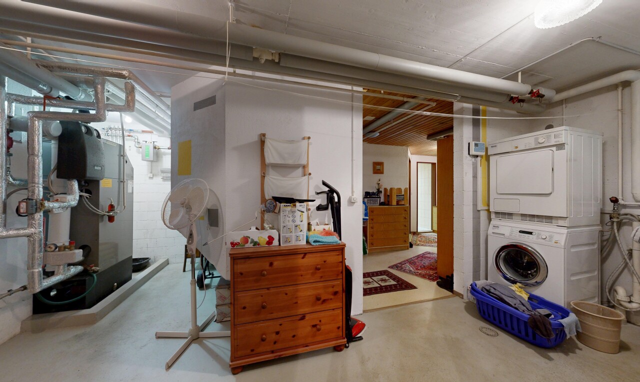 buanderie avec concrete floor, sol en béton, buanderie, lave-linge et sèche-linge superposés, et inside property