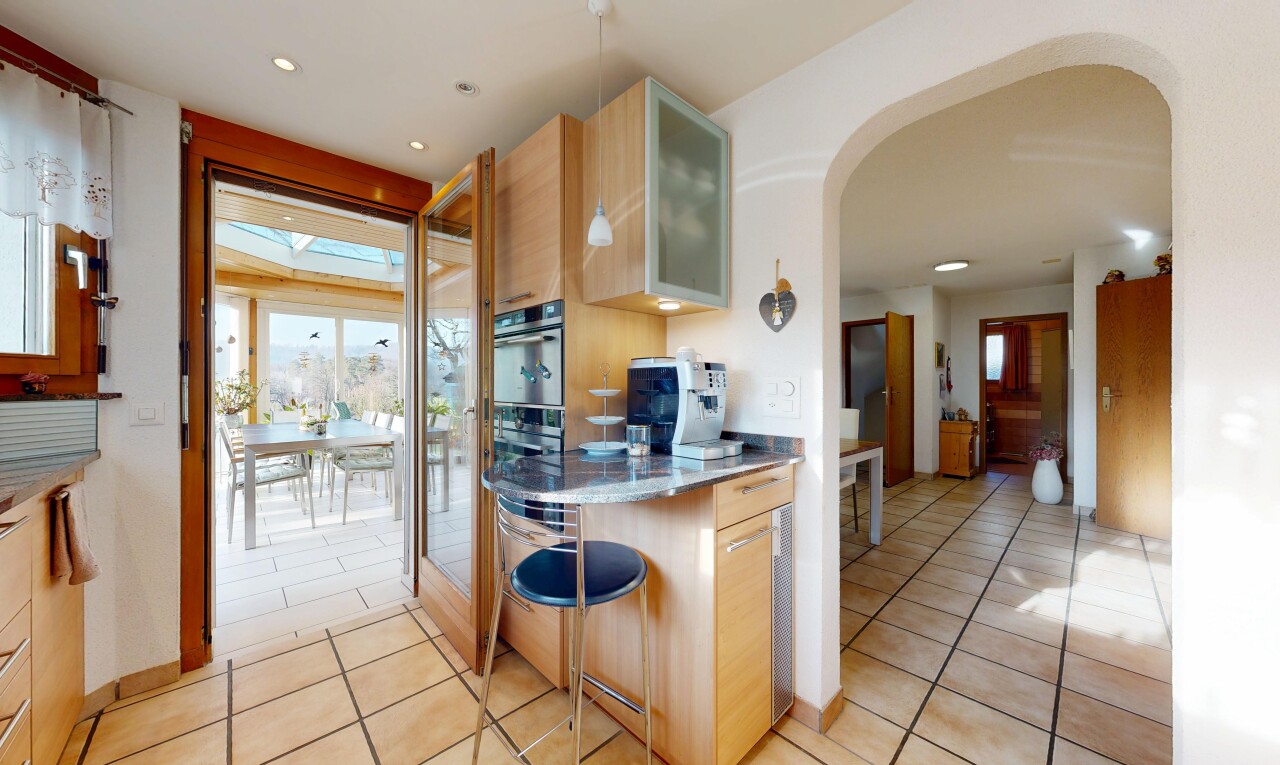 cuisine avec curved countertops, armoires avec insert en verre, glass insert cabinets, drywall, et cloison sèche