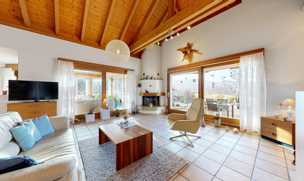 salon avec inside property, wood ceiling, plafond en bois, télévision, et high ceiling
