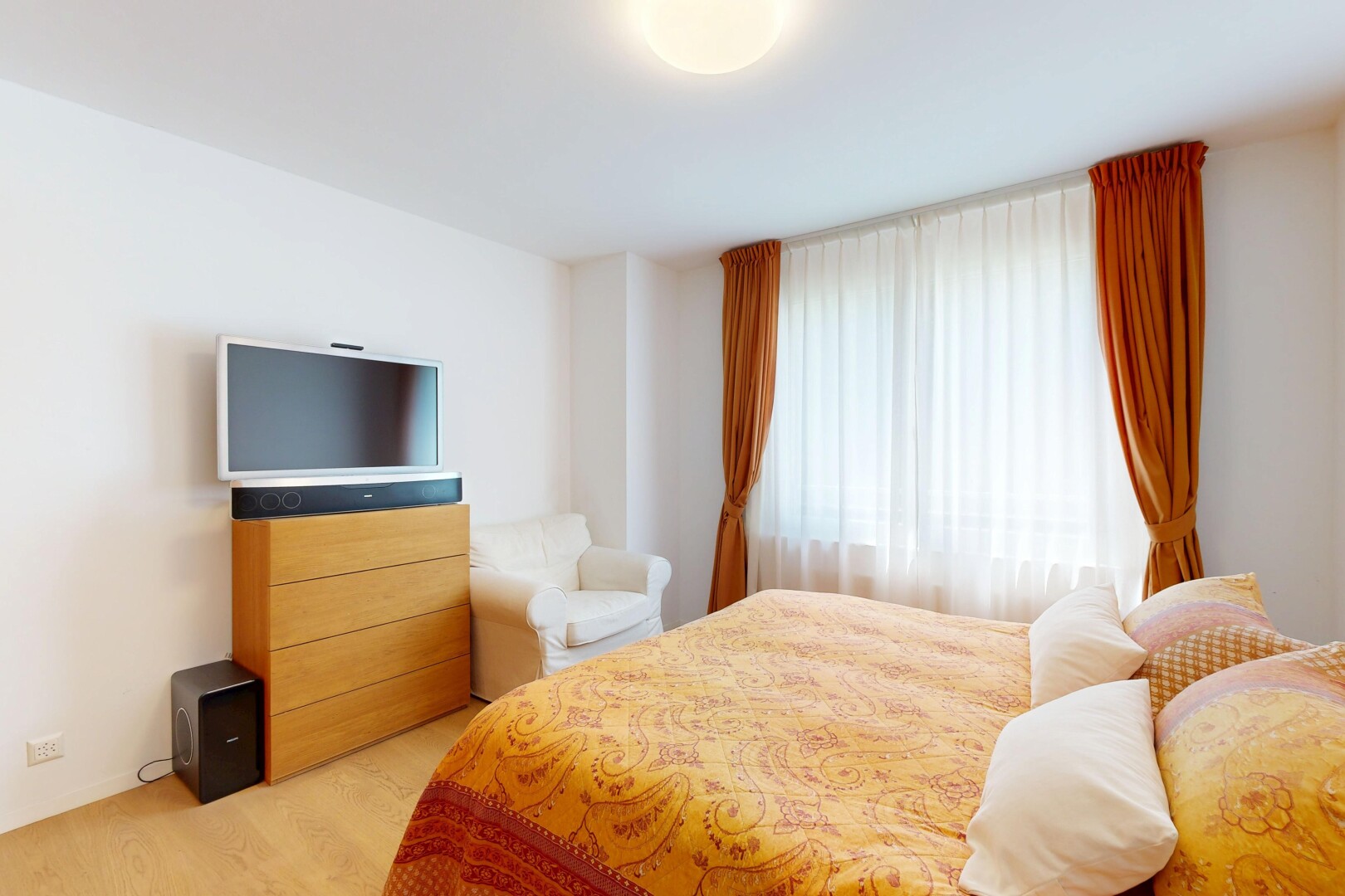 zimmer / schlafzimmer mit fernseher, gipskartonwand, drywall, inside property, und holzfußboden