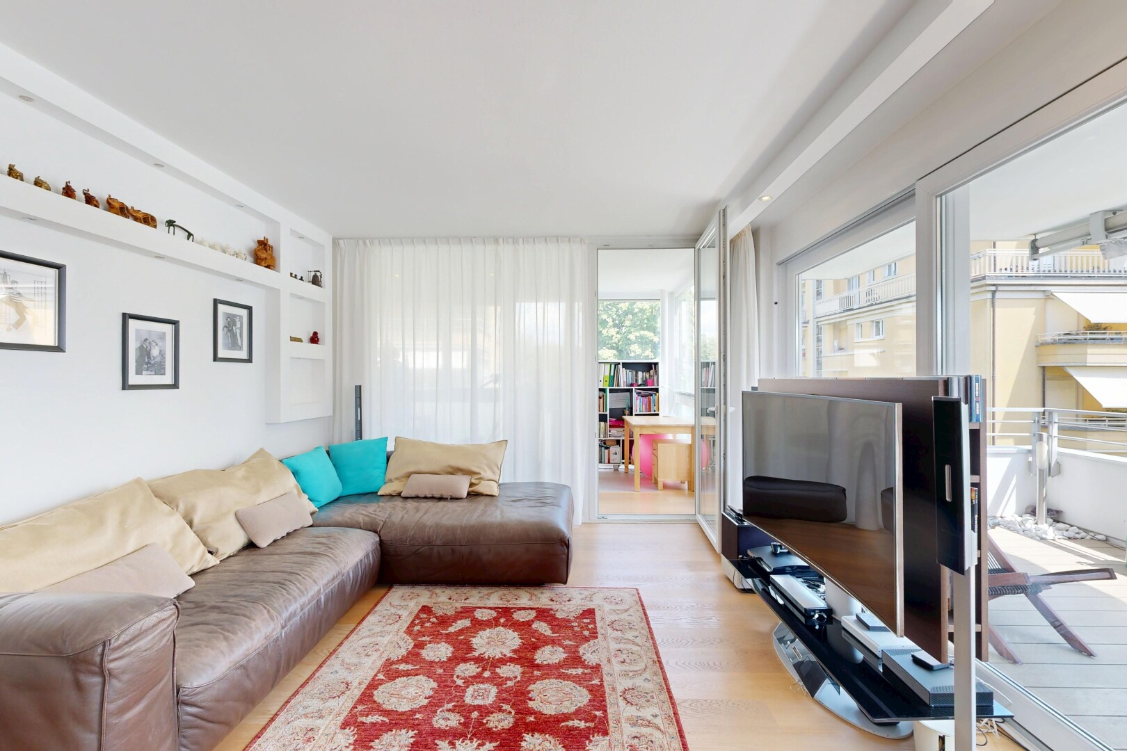 wohnzimmer mit inside property, holzfußboden, wood finish floor, eingebaute regale, und built in shelves