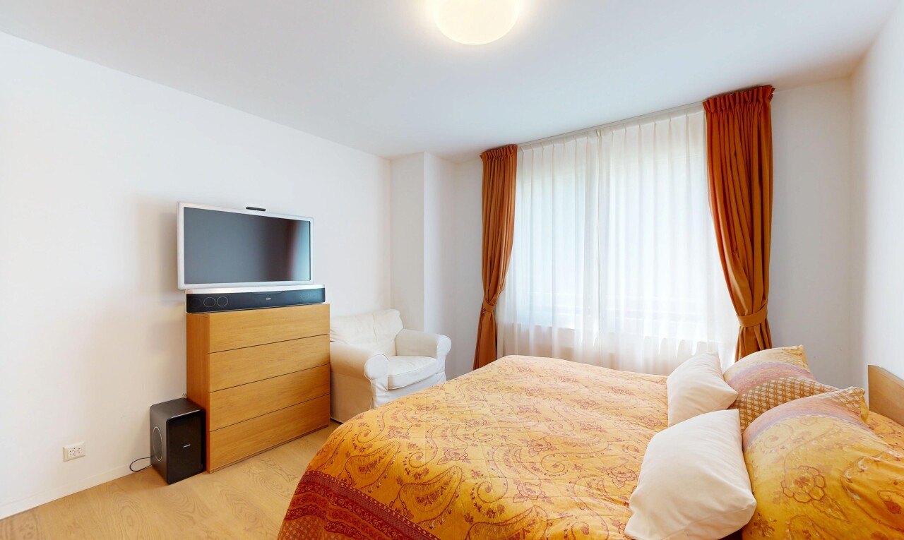 zimmer / schlafzimmer mit fernseher, gipskartonwand, drywall, inside property, und holzfußboden