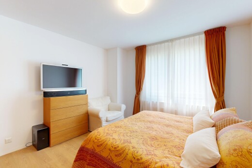 zimmer / schlafzimmer mit fernseher, gipskartonwand, drywall, inside property, und holzfußboden