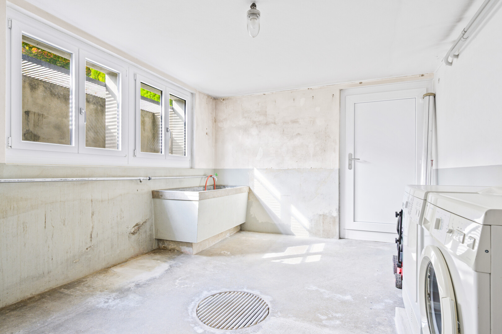 salle de bains avec concrete floor, sol en béton, unfinished concrete floor, inside property, et natural light