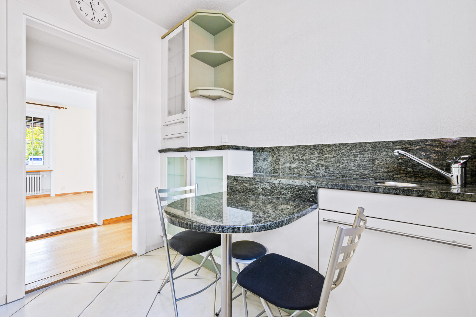 cuisine avec plans de travail en pierre, armoires blanches, drywall, cloison sèche, et étagères ouvertes