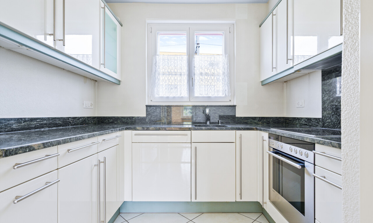 küche mit weiße schränke, ofen, natural light, natürliches licht, und tile floor