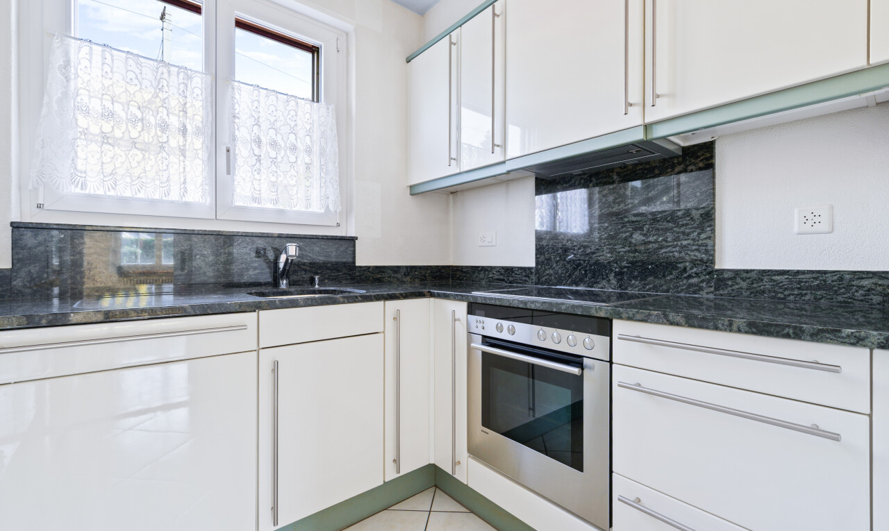 küche mit ofen, weiße schränke, inside property, natural light, und natürliches licht