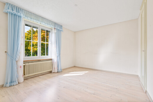 pièce vide avec wood finish floor, sol en finition bois, natural light, lumière naturelle, et radiateur