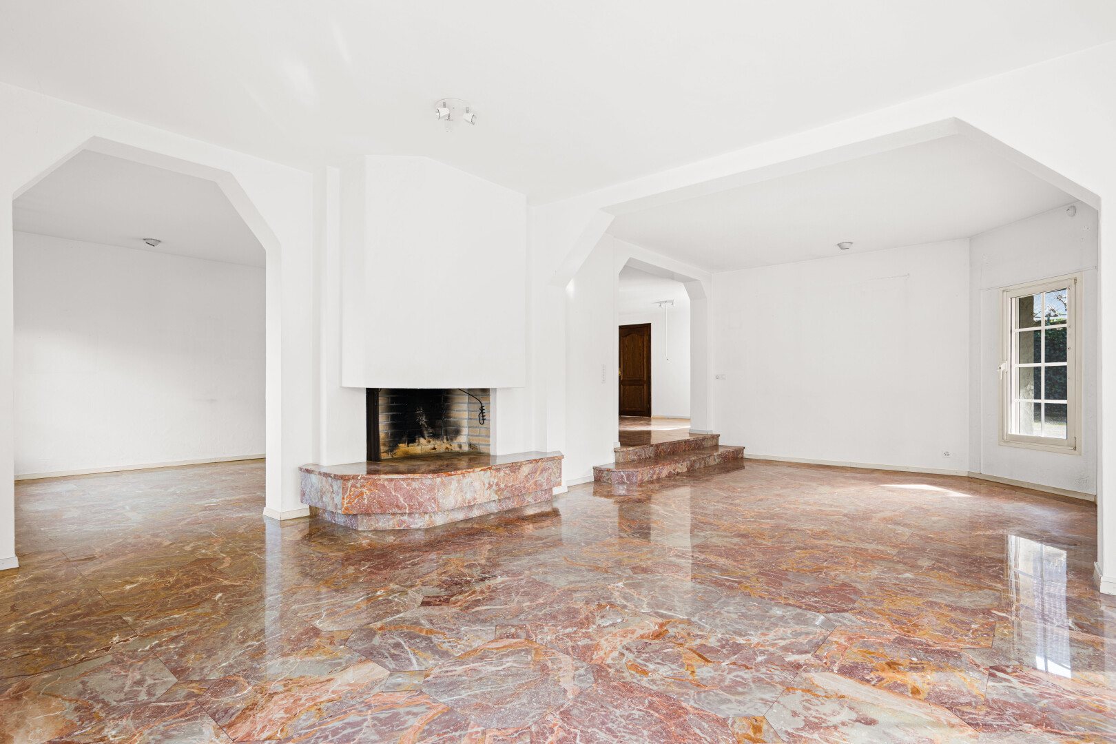 wohnzimmer mit gewölbte gehwege, kamin, marmorboden, marble finish floor, und marble tile