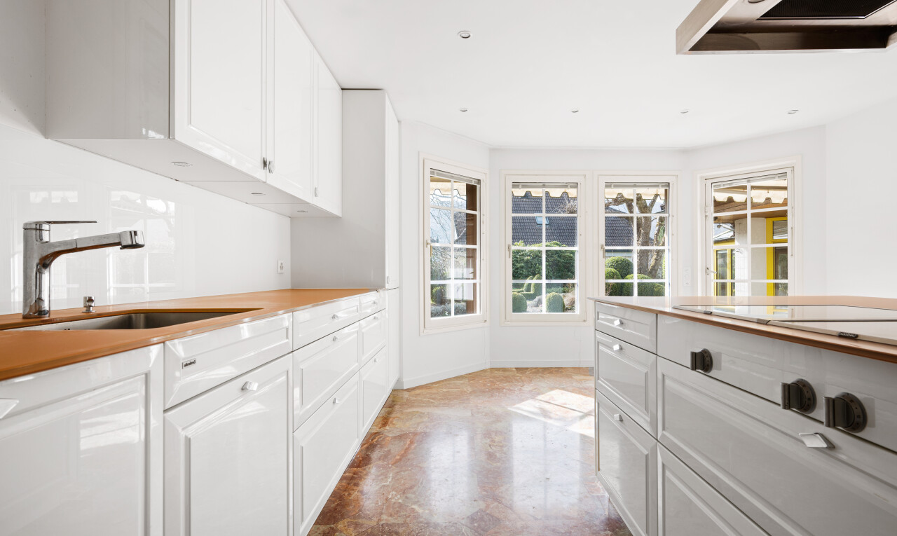 cuisine avec white cabinets, armoires blanches, hotte, évier, et raised cabinets