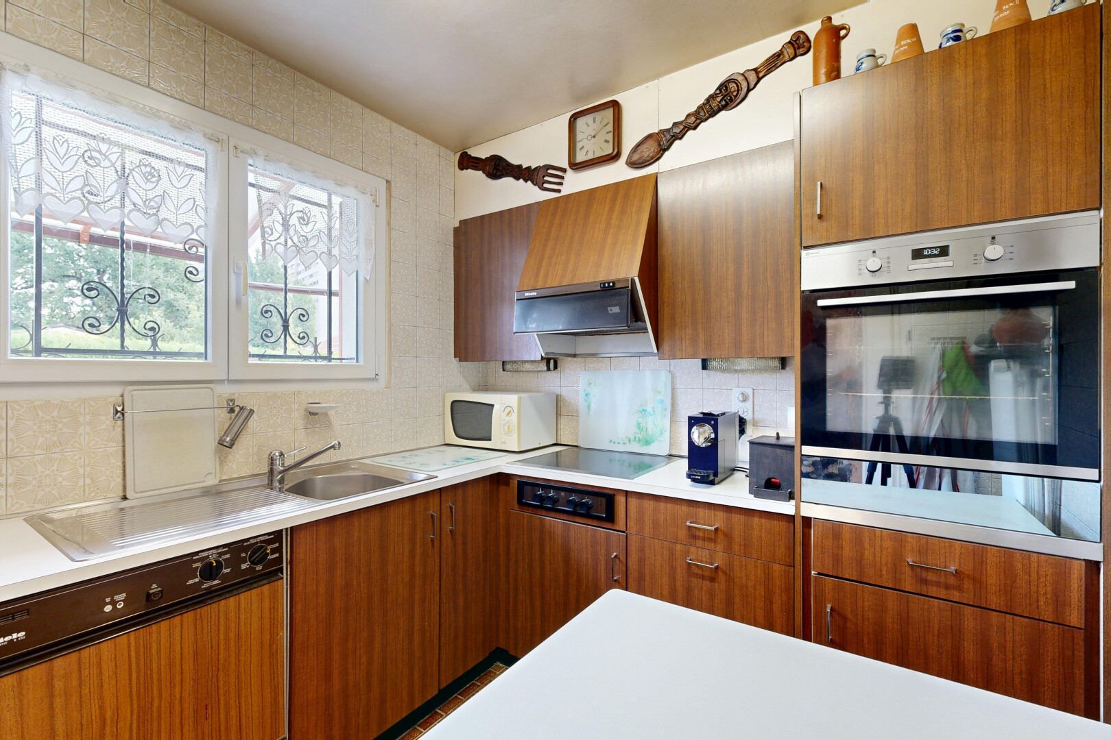 kitchen featuring dishwasher, light countertops, tasteful backsplash, wood finish cabinetry, and oven