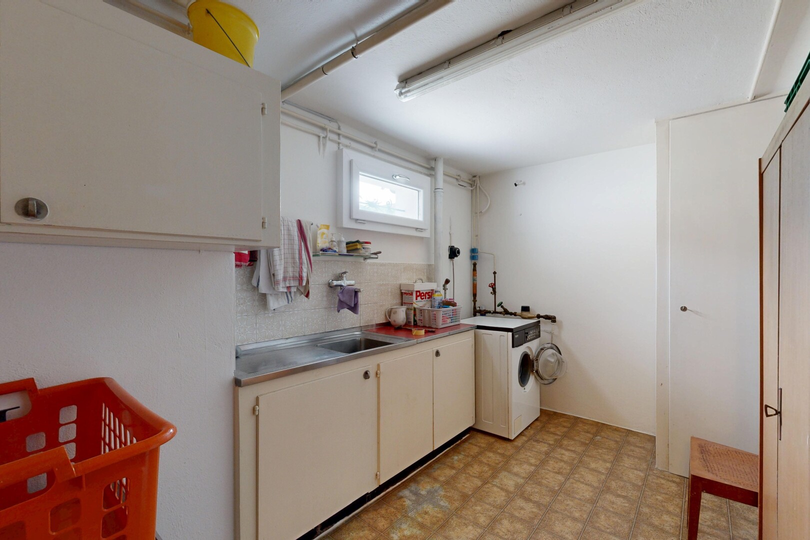 kitchen featuring light flooring, washer / clothes dryer, and cream cabinets