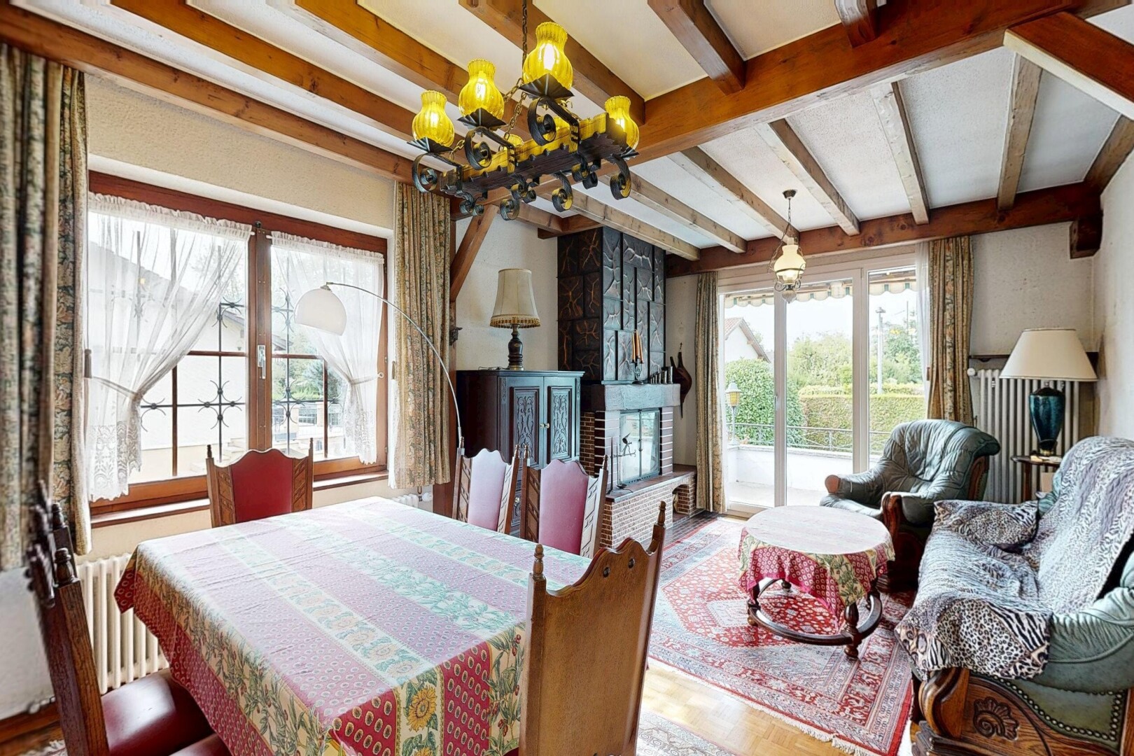 living / dining room featuring beam ceiling, radiator, hanging light fixtures, and wood finished floors