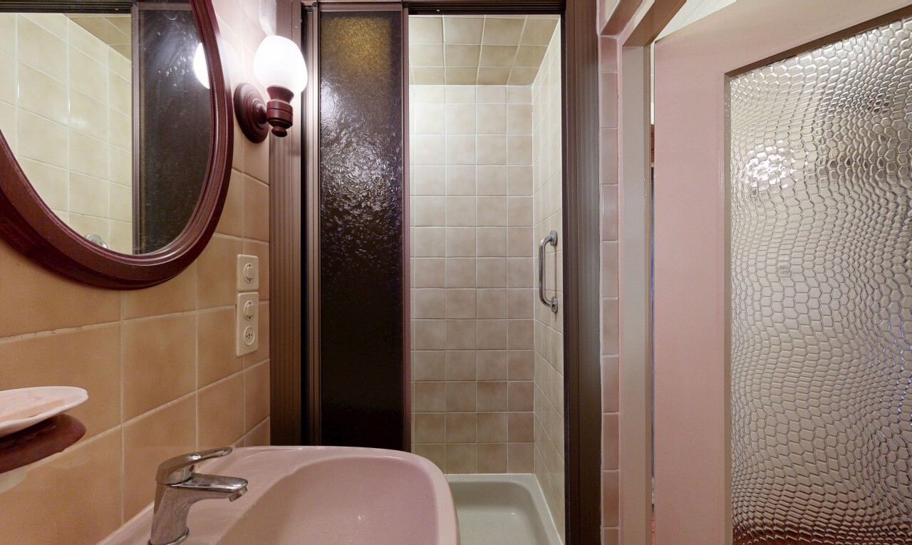 full bathroom featuring a stall shower and tile walls