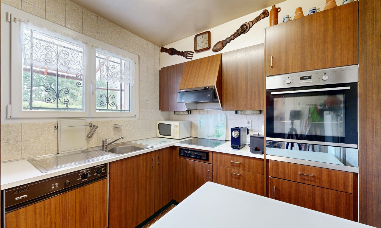 kitchen featuring dishwasher, light countertops, tasteful backsplash, wood finish cabinetry, and oven