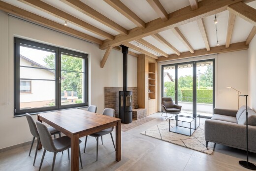 living / dining room featuring beam ceiling, radiator, hanging light fixtures, and wood finished floors