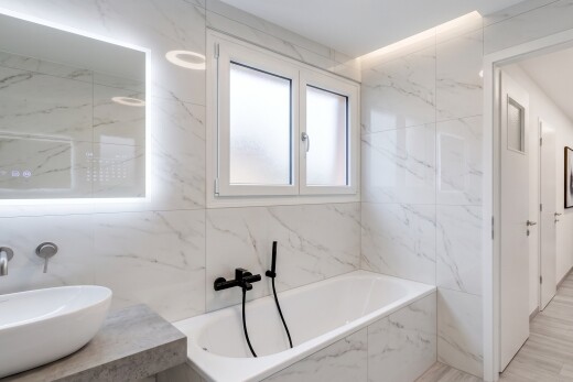 full bathroom featuring a bath, tile walls, and light tile patterned floors