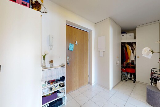 couloir avec inside property, cloison sèche, drywall, sol en carrelage, et tile floor