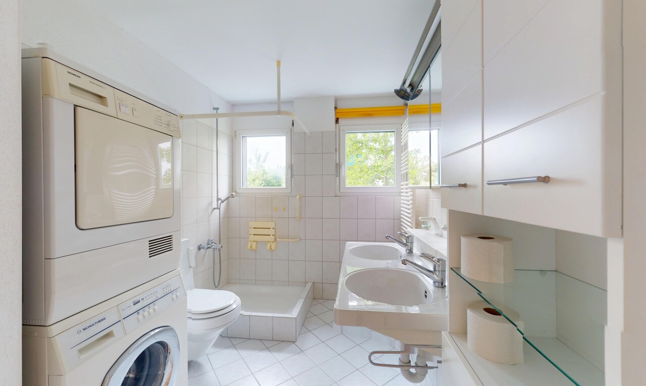 salle de bains avec lave-linge et sèche-linge superposés, sol en carrelage, tile floor, douche, et inside property