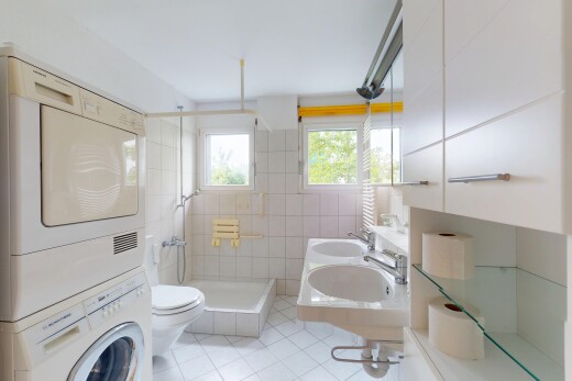 salle de bains avec lave-linge et sèche-linge superposés, sol en carrelage, tile floor, douche, et inside property