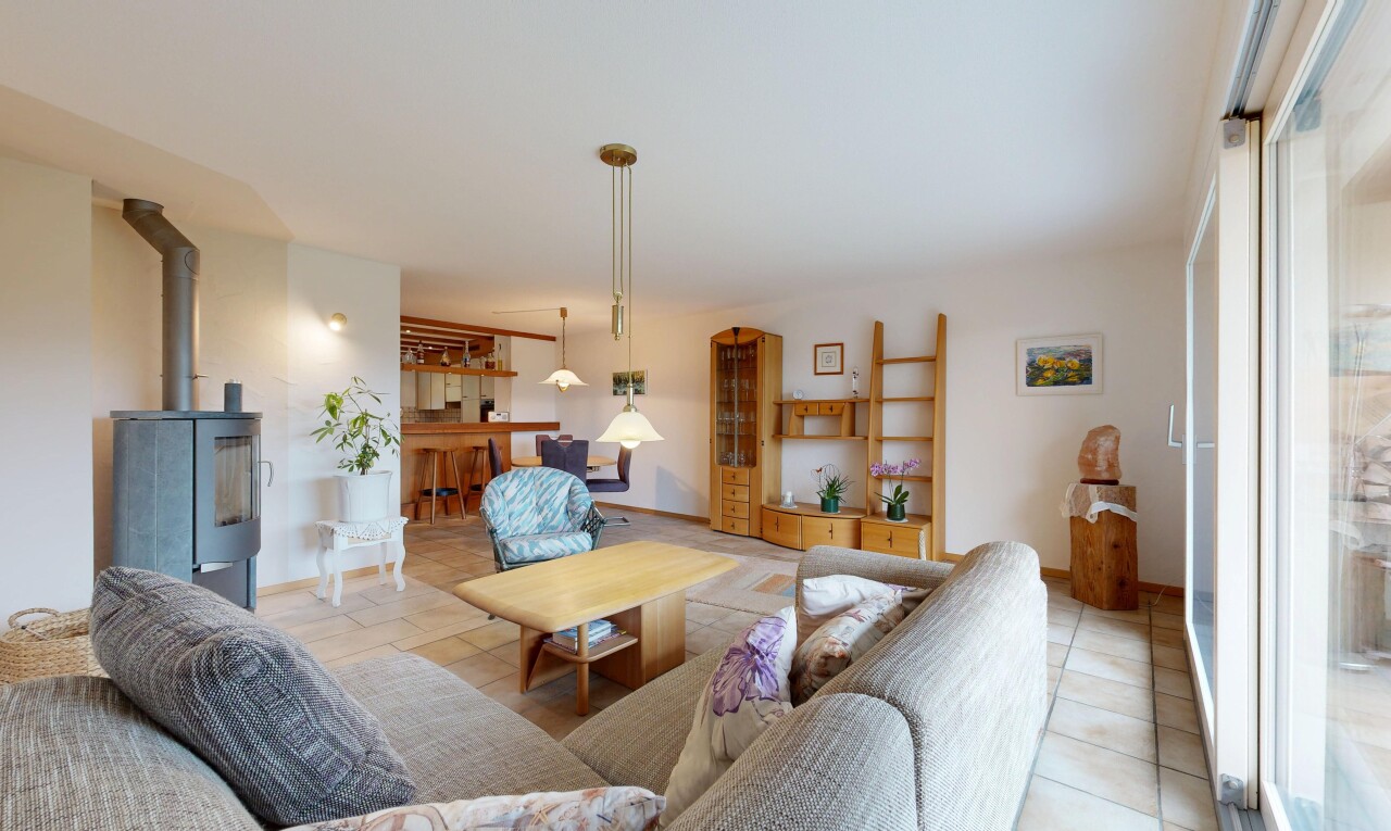 living room featuring tile patterned floors and a wood stove