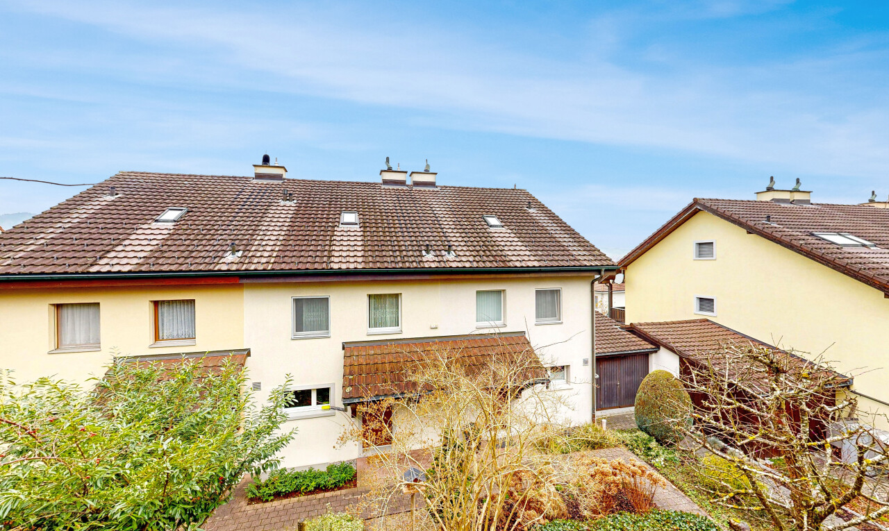 view of property with stucco siding, a chimney, and a tile roof