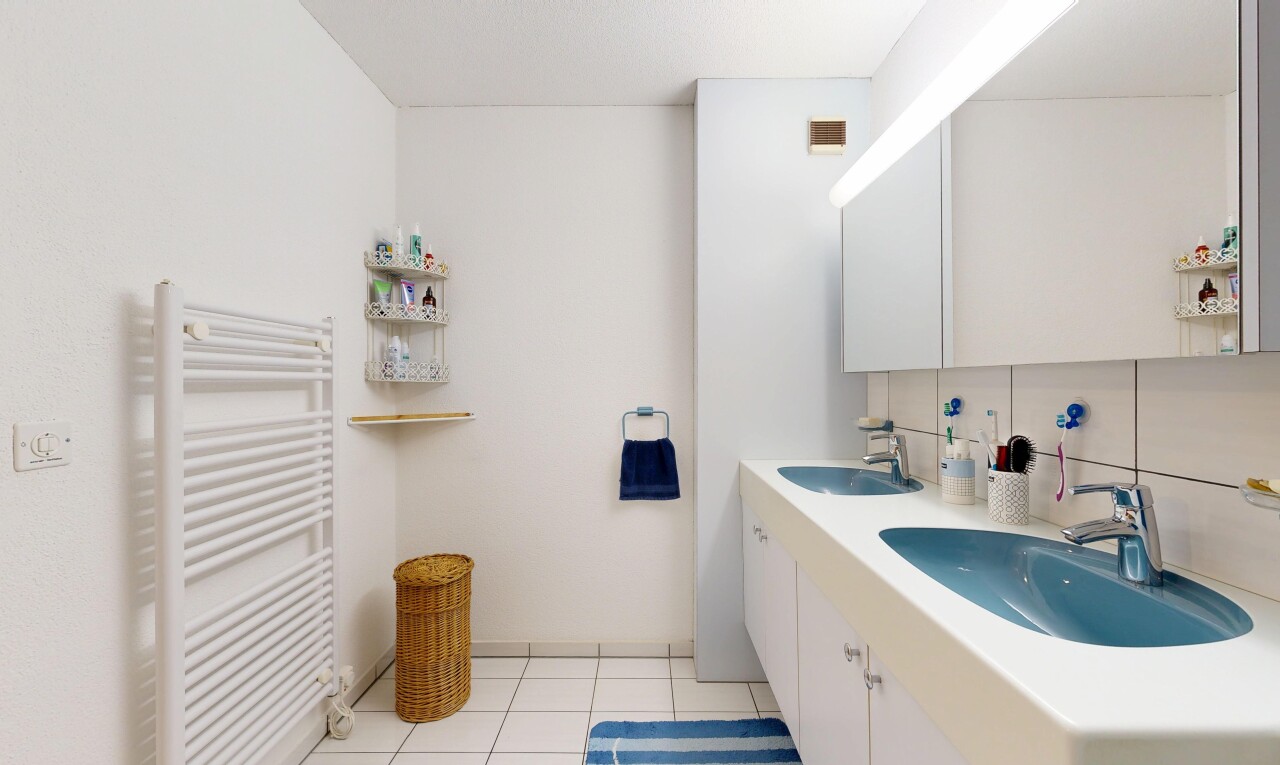 full bathroom featuring radiator, tasteful backsplash, double vanity, light tile patterned floors, and a towel warmer