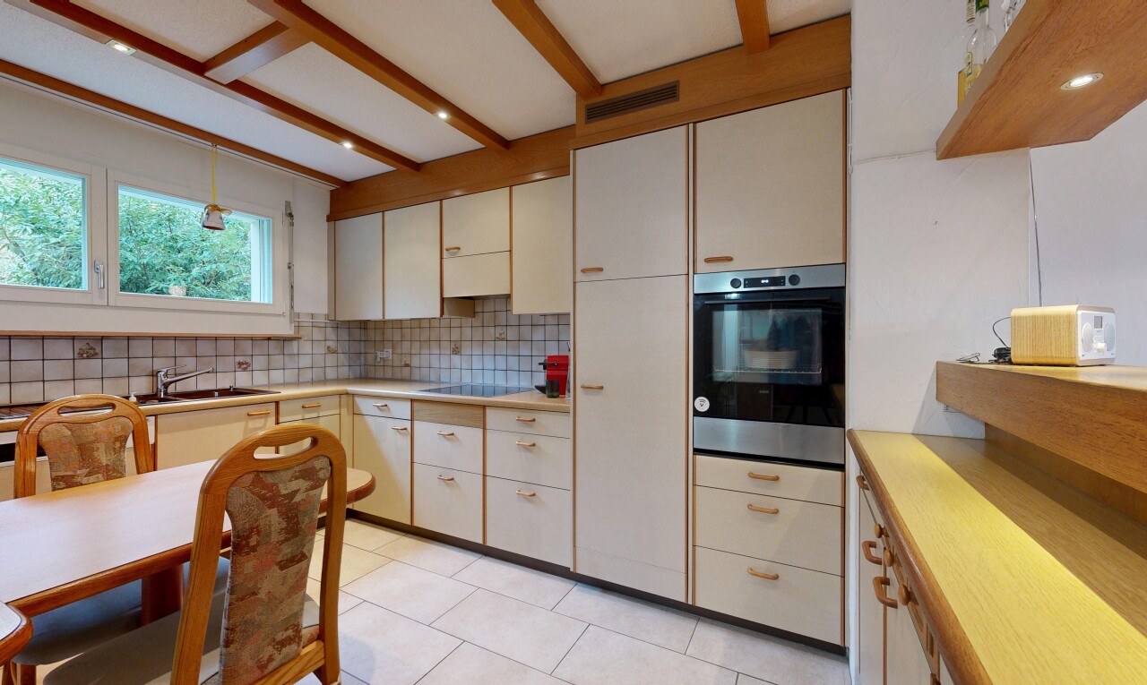 kitchen featuring stainless steel oven, light countertops, light tile patterned floors, tasteful backsplash, and hanging light fixtures