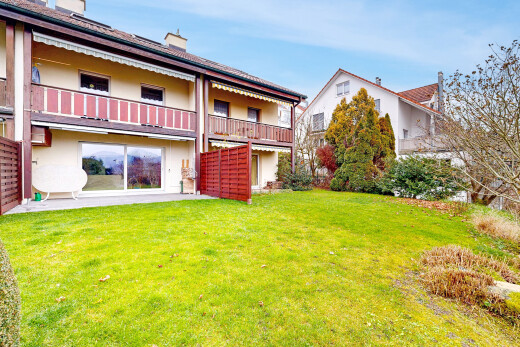 outdoor house featuring stucco siding, a yard, a balcony, a chimney, and a patio area