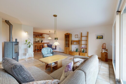 living room featuring tile patterned floors and a wood stove