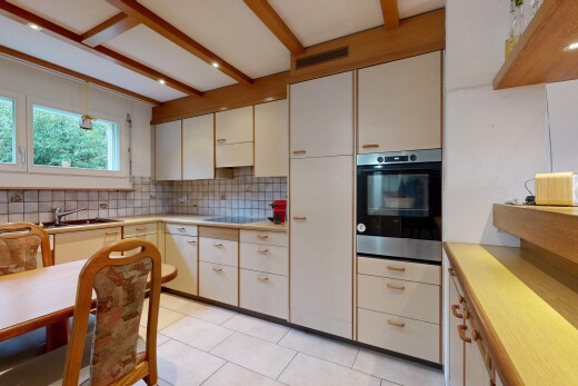 kitchen featuring stainless steel oven, light countertops, light tile patterned floors, tasteful backsplash, and hanging light fixtures