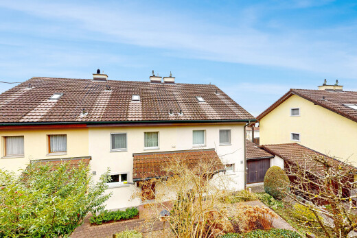 view of property with stucco siding, a chimney, and a tile roof