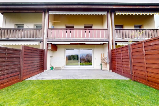 façade avec clôture, property visible, bardage en stuc, balcon, et pelouse