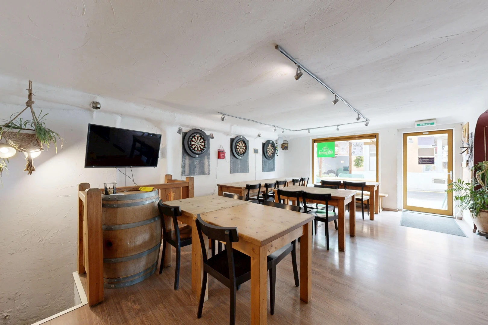 salle à manger avec accès à l'extérieur, télévision, sol en finition bois, wood finish floor, et éclairage sur rail