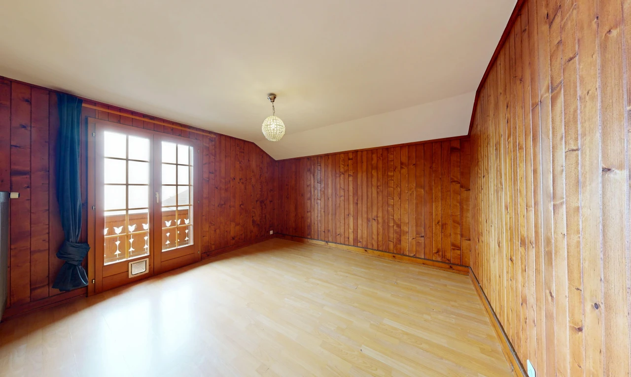 pièce vide avec plafond voûté, vaulted ceiling, sol en finition bois, wood finish floor, et dated wood wall