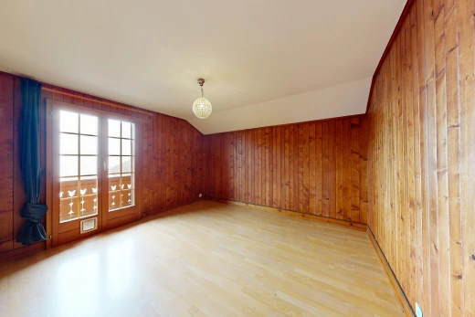 pièce vide avec plafond voûté, vaulted ceiling, sol en finition bois, wood finish floor, et dated wood wall
