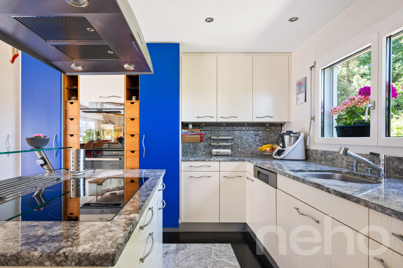 cuisine avec hotte, plans de travail en pierre, stone countertops, dark countertops, et dosseret