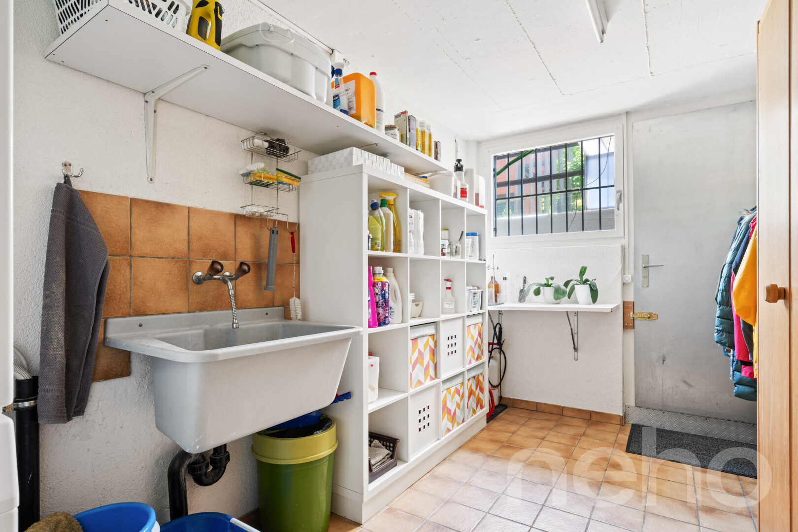 buanderie avec évier, lumière naturelle, light floor, drywall, et cloison sèche