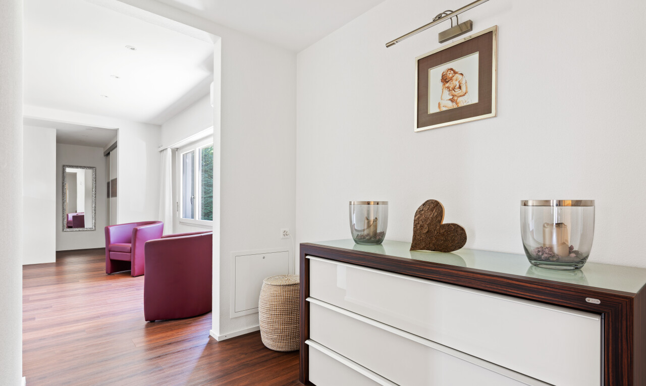 couloir avec wood finish floor, sol en finition bois, drywall, cloison sèche, et dark floor