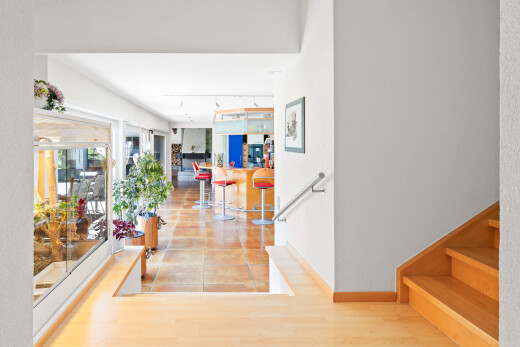 couloir avec escaliers, éclairage sur rail, wood finish floor, sol en finition bois, et inside property
