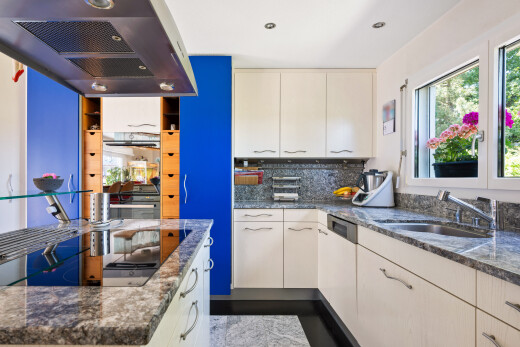 cuisine avec hotte, plans de travail en pierre, stone countertops, dark countertops, et dosseret