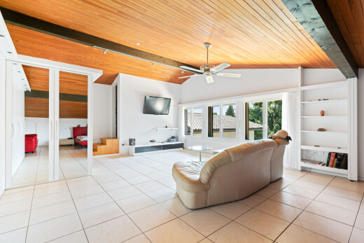 salon avec étagères intégrées, high end ceiling, plafond en bois, wood ceiling, et ventilateur de plafond